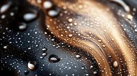 Dramatic macro shot of water droplets on dark surface with golden light creating abstract pattern and curves. Artistic background with selective focus.
