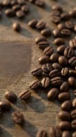 Roasted coffee beans scattered on rustic wooden surface with warm lighting creating aromatic cafe atmosphere for beverage and culinary projects.