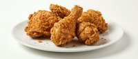 Crispy golden fried chicken pieces served on white plate, ready for restaurant menus, food delivery apps, and culinary marketing materials.