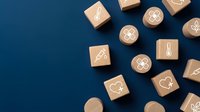 Wooden blocks with medical healthcare icons scattered on blue background. Hospital symbols including stethoscope, heart, cross for clinic branding materials.