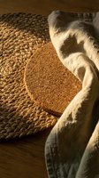 Cocoa powder spilling from burlap sack onto woven basket surface with warm lighting creating rustic kitchen atmosphere for baking and cooking concepts.