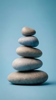 Balanced stack of five smooth river stones arranged in pyramid formation on blue background representing zen meditation wellness and mindfulness concepts.