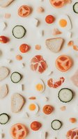 Fresh breakfast ingredients pattern with sliced tomatoes, cucumbers, ham, bread and fried eggs on white background, flat lay food composition.