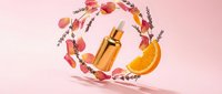 Luxury golden dropper bottle with orange slice and rose petals on pink background, natural skincare serum concept for beauty and cosmetic branding.