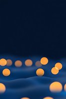 Glowing orange spheres floating over abstract blue waves create dreamy minimalist scene with soft bokeh effect and dark atmospheric background.