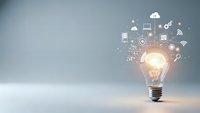 Glowing light bulb with digital technology icons floating above representing innovation, creativity, and smart solutions for business development.