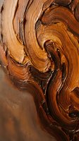 Rich brown oil paint swirls create dynamic textured brushstrokes with warm amber and copper tones for artistic backgrounds and creative projects.