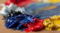 Vibrant acrylic paint colors mixed on artist palette with paintbrush, creative art supplies for painting and artistic expression in studio workspace.