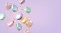 Colorful macarons falling through air with crumbs on soft pink background. French pastry dessert concept for bakery and confectionery design projects.