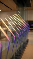 Modern glass railing with colorful LED lighting in contemporary office building interior showcasing architectural design and innovative illumination technology.