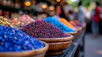 Vibrant spices and herbs displayed in traditional wooden bowls at market stall, featuring striking blue, purple and orange natural dyes and seasonings in selective focus.