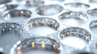 Water droplets on metallic silver surface creating abstract pattern with bokeh light effects and reflections, macro photography showing surface tension and natural geometry.