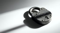 Antique padlock with keyhole isolated on white background, casting dramatic shadow, suitable for security, vintage, and design projects.