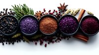 Colorful spices and seasonings in metal bowls with star anise and cinnamon sticks arranged on white background for culinary cooking and food preparation.