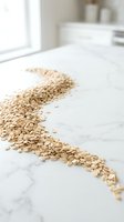 Rolled oats scattered on white marble countertop in bright kitchen setting, representing healthy breakfast ingredients and nutrition for food styling and culinary content.