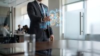 Professional businessman in dark suit interacting with futuristic holographic interface displaying digital network connections in modern office environment.