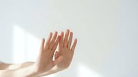 Two open hands reaching upward in gentle morning light creating peaceful gesture of hope, prayer, or receiving blessings in minimalist white setting.
