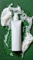 White pump bottle surrounded by soap bubbles and foam on green background, ideal for skincare and cosmetic product marketing.