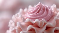 Delicate pink buttercream swirls with ruffled edges and soft sugar sparkles create an elegant pastel dessert background for wedding and celebration designs.