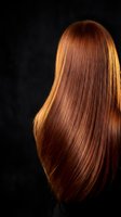 Luxurious long auburn hair flowing against dark background showcasing healthy shine and smooth texture for beauty and haircare concepts.