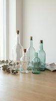 Collection of vintage glass bottles with cork stoppers arranged on wooden surface near window for home decor and interior design projects.