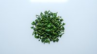 Chopped fresh green herbs pile isolated on white background, ready for culinary design and food styling projects.