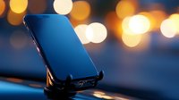 Modern smartphone on car dashboard mount against blurred city lights background creating atmospheric evening mood with bokeh effects.
