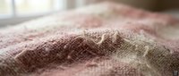Soft pink knitted fabric texture with natural fibers showing detailed weave pattern and cozy material surface for textile and fashion design projects.