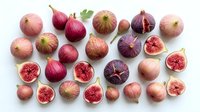 Fresh figs collection with whole and sliced fruits showing red flesh, arranged on white background for culinary and healthy eating designs.
