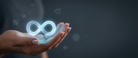 Cropped hand holding glowing infinity symbol representing endless possibilities, sustainable growth, and circular economy concepts for business and technology presentations.