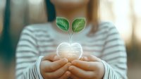 Young woman holding glowing heart shape with growing green plant sprout, representing hope, environmental care and sustainable future concept.