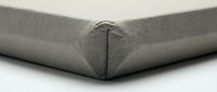 Gray fitted bed sheet corner with elastic band on white mattress showing textile detail and home bedding essentials for bedroom decor.
