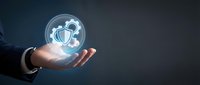 Businessman hand holding glowing digital shield with security icons, representing cybersecurity protection, data safety, and network defense solutions for business.