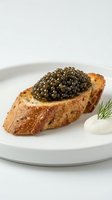 Toasted bread slice topped with caviar pearls, served on white plate with sour cream and fresh dill garnish. Luxury appetizer for fine dining and gourmet cuisine.
