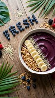 Acai smoothie bowl topped with banana slices, granola, and hemp seeds on rustic wood, surrounded by fresh blueberries spelling FRESH.
