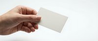 Hand holding blank white business card mockup on clean background for branding and corporate identity design projects.