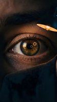 Close-up of a male individual with dark skin tone and golden-brown iris displaying gear reflections, wearing dark clothing, symbolizing vision, innovation, and strategic thinking for business concepts.