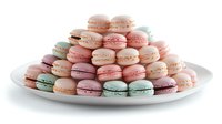 Colorful French macarons in pastel pink, mint green, purple and cream colors arranged on white ceramic plate, sweet meringue cookies with filling for dessert menu.