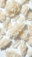 Pale crystalline mineral chunks with translucent texture scattered on white background, isolated specimens suitable for geology, science education, wellness products, and natural ingredient packaging design.