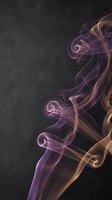 Abstract purple and golden smoke swirls on dark background creating elegant flowing patterns for luxury design projects and artistic compositions.