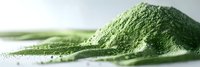 Heap of green matcha tea powder on white surface, close-up view showing fine texture and vibrant color for culinary and wellness applications.
