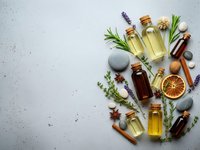 Natural essential oils in glass bottles with herbs, spices and aromatherapy ingredients on white background for wellness and spa treatments.