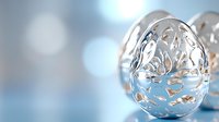 Decorative silver filigree Easter egg with delicate cutout pattern on soft blue bokeh background. Elegant holiday ornament with metallic shine and intricate details.