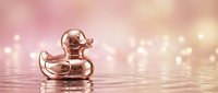 Elegant rose gold rubber duck floating on water with soft bokeh lights creating luxurious spa-like atmosphere for wellness and relaxation concepts.