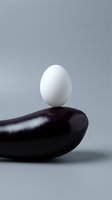 White egg balanced on smooth black stone against gray background symbolizing harmony, balance and zen meditation concepts for wellness design.