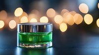 Green cosmetic cream in luxury glass jar on dark background with golden bokeh lights, elegant skincare product photography for beauty industry.