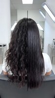 Hair straightening before and after comparison showing curly to straight transformation at professional salon with modern equipment and natural lighting.