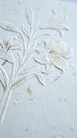 Elegant white and gold embossed floral pattern on textured paper surface with lily motifs and decorative botanical elements for luxury stationery design.
