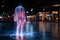Glowing silhouette of man made of pink and blue light particles standing on reflective surface at night with bokeh city lights in background.