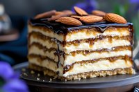 Layered no-bake dessert with chocolate drizzle and almonds on top, creamy vanilla filling between crispy wafer layers creates elegant pastry slice on dark plate.